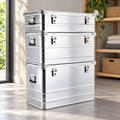 Three silver aluminum boxes stacked in a home storage corner; combination illustration, each box sold separately