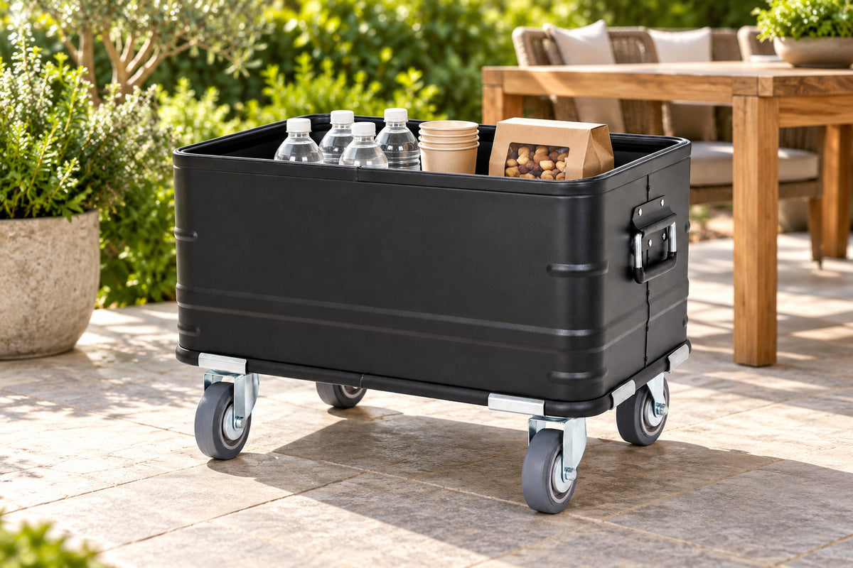 Black rolling storage bin on a paved patio with packaged drinks and gathering supplies; props not included