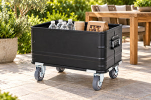 Black rolling storage bin on a paved patio with packaged drinks and gathering supplies; props not included