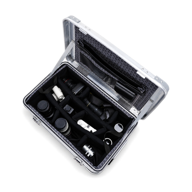 Interior layout reference: silver case with padded dividers and lid document organizer; cameras and lenses not included