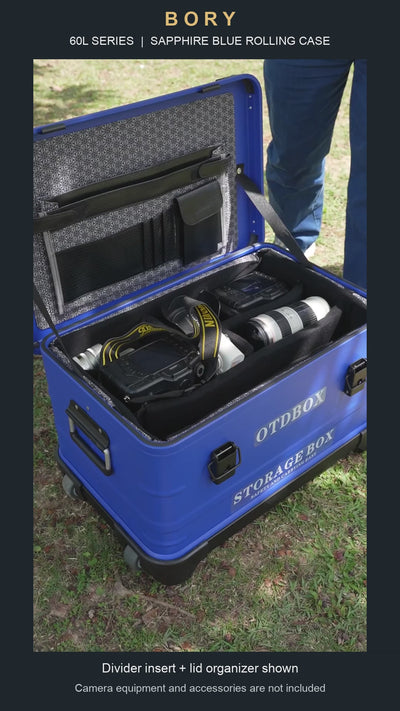 Sapphire blue 60L-series aluminum rolling case with padded dividers and lid organizer; camera equipment shown is not included